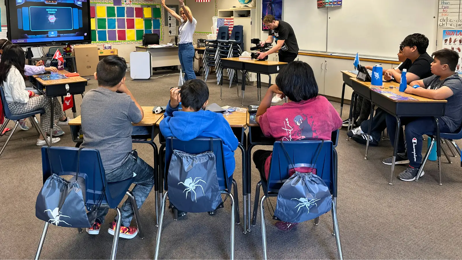 QUEST Students team backpacks on the backs of their seats