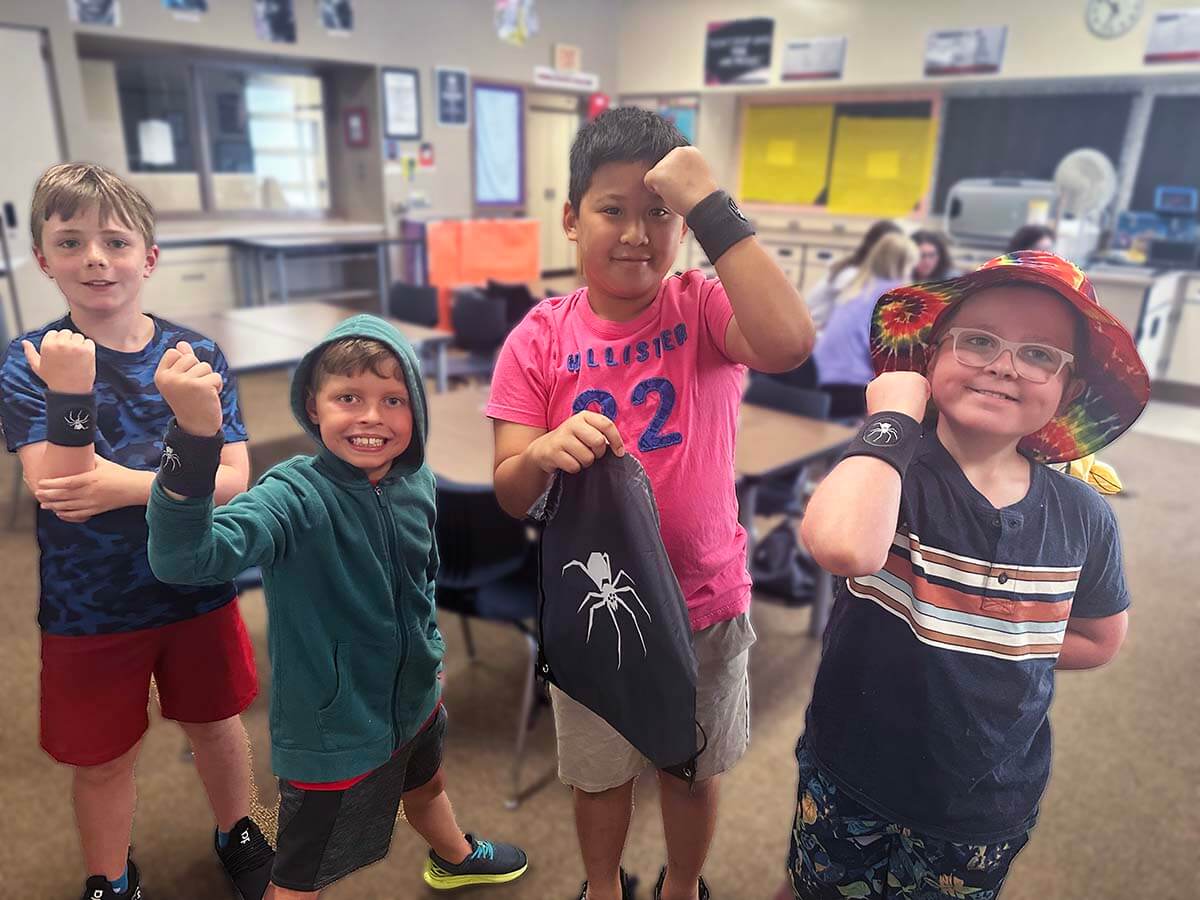 QUEST students on the black spider team showing off their team wristbands